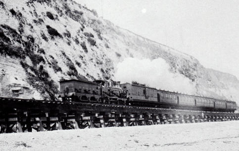 A South Eastern and Chatham Railway train leaving Dover for Folkestone c.1910.  Until the 1920s the line between Dover Town Station and Shakespeare Cliff tunnel was carried on a low timber trestle.